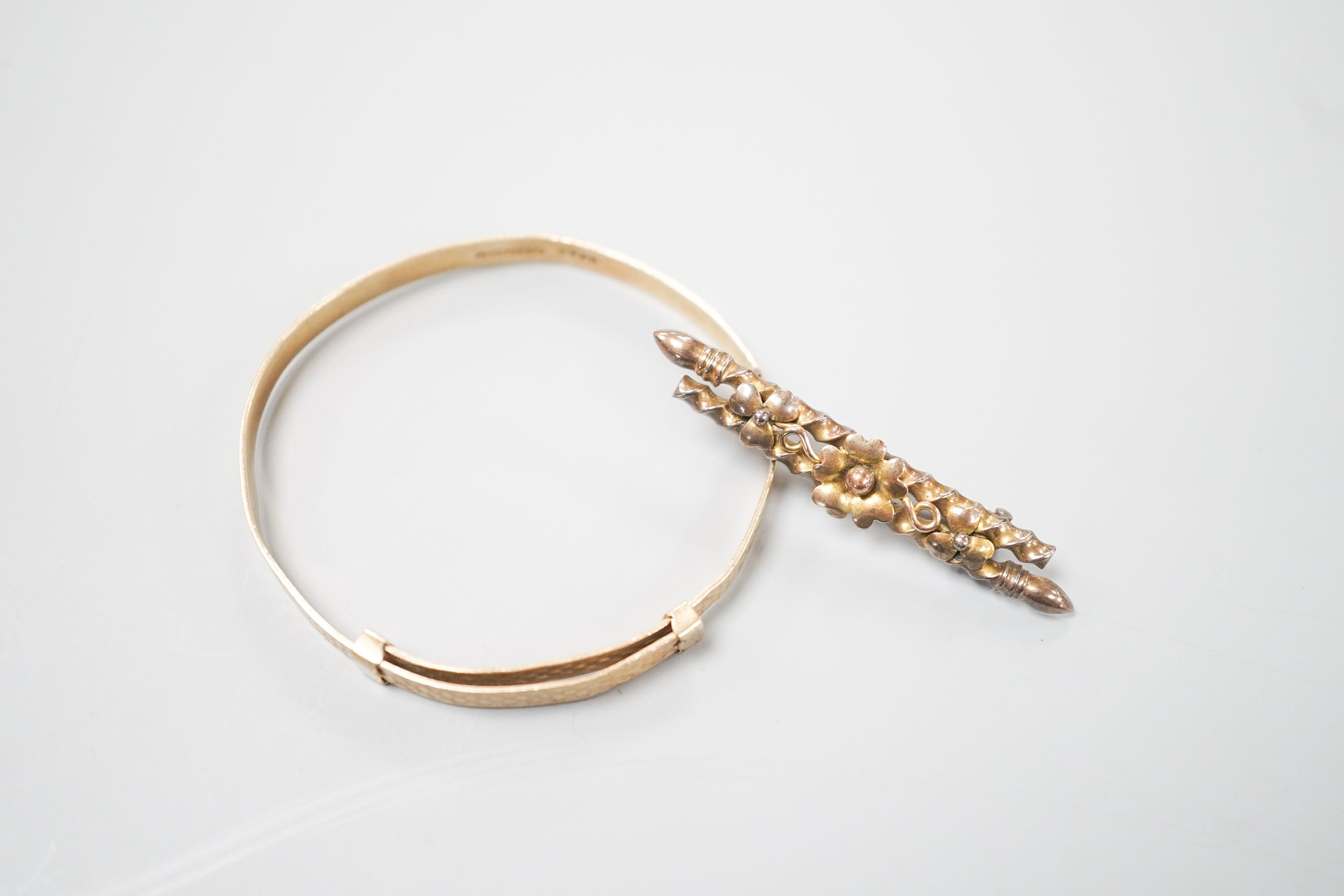 A modern 9ct gold child's bangle and a late Victorian 9ct gold bar brooch, gross 6.7 grams.